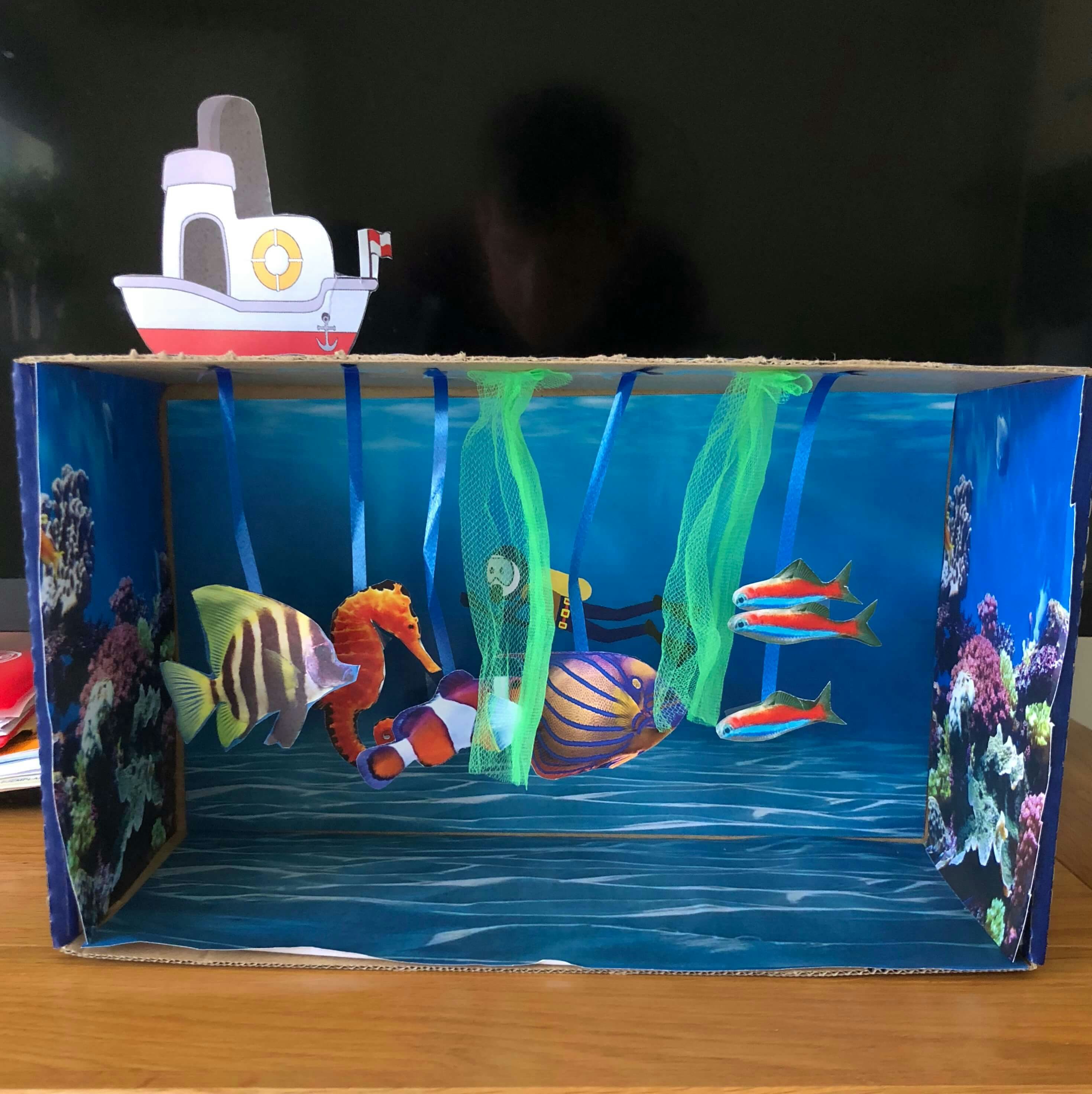 an aquarium which is just bits of paper and ribbon stuck in a shoebox