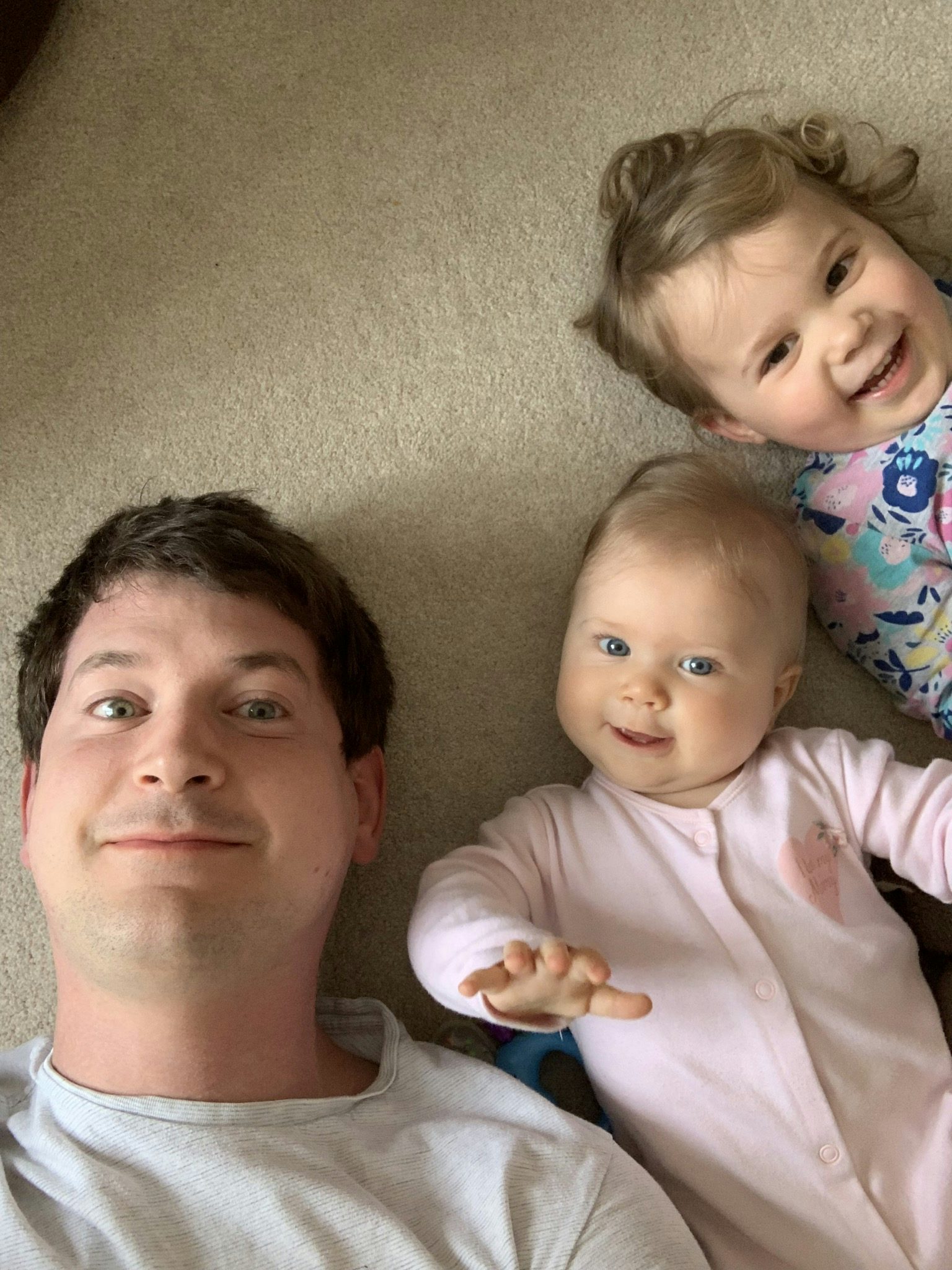 Me and my two kids, lying on the floor, looking up at the camera.