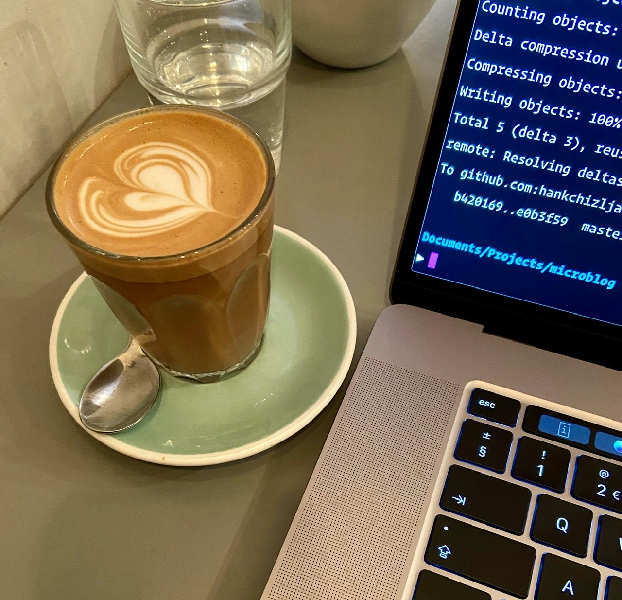 A cortado coffee next to my MacBook Pro