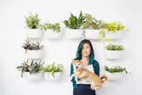 Susan and Mango surrounded by hanging baskets of plants