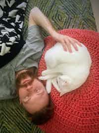 Stephen and a white cat take a nap together