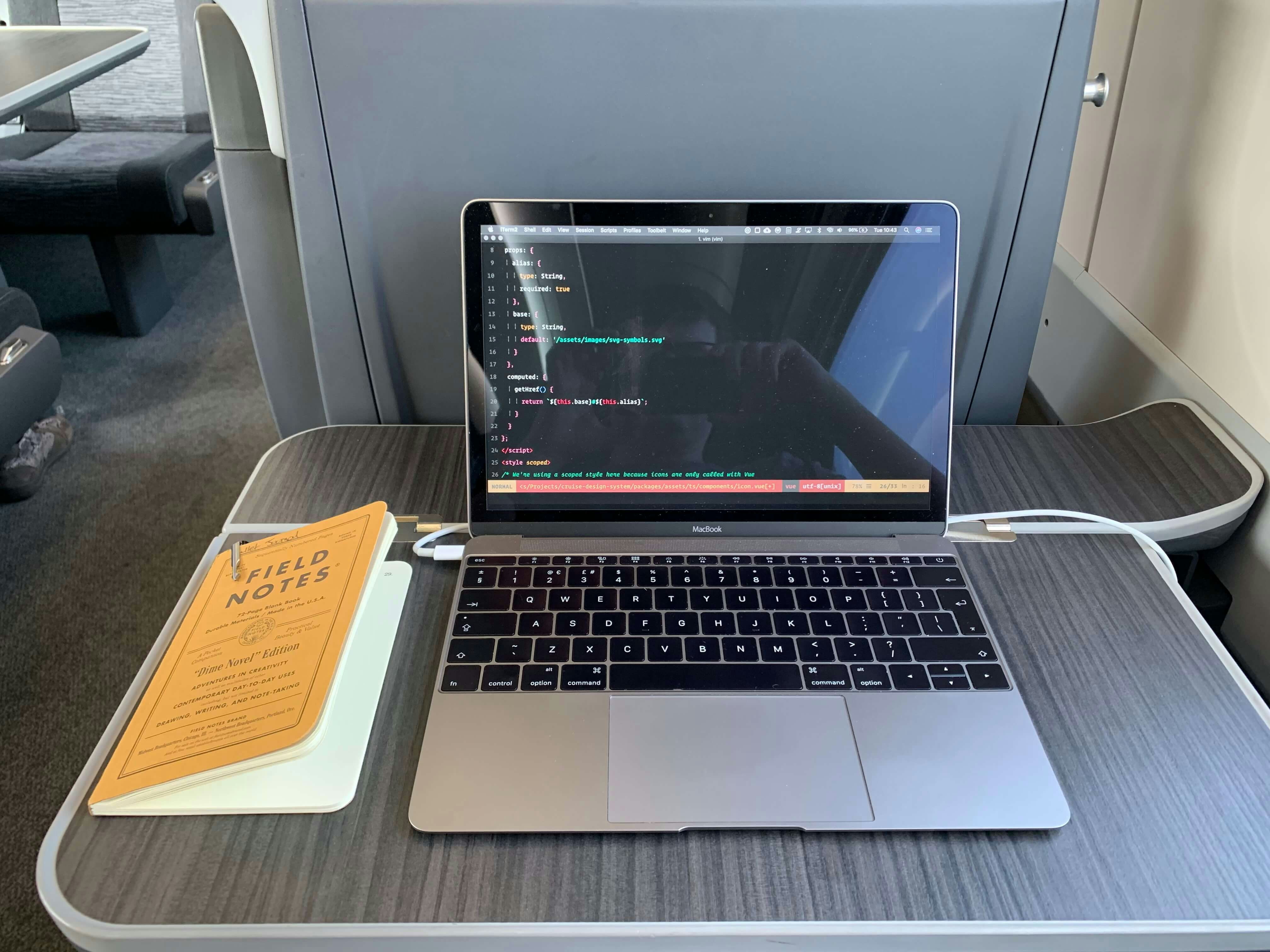 A macbook and field notes notepad on a train desk